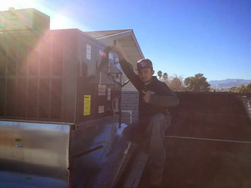 HVAC technician performing HVAC Inspection on a rooftop unit in Brambleton